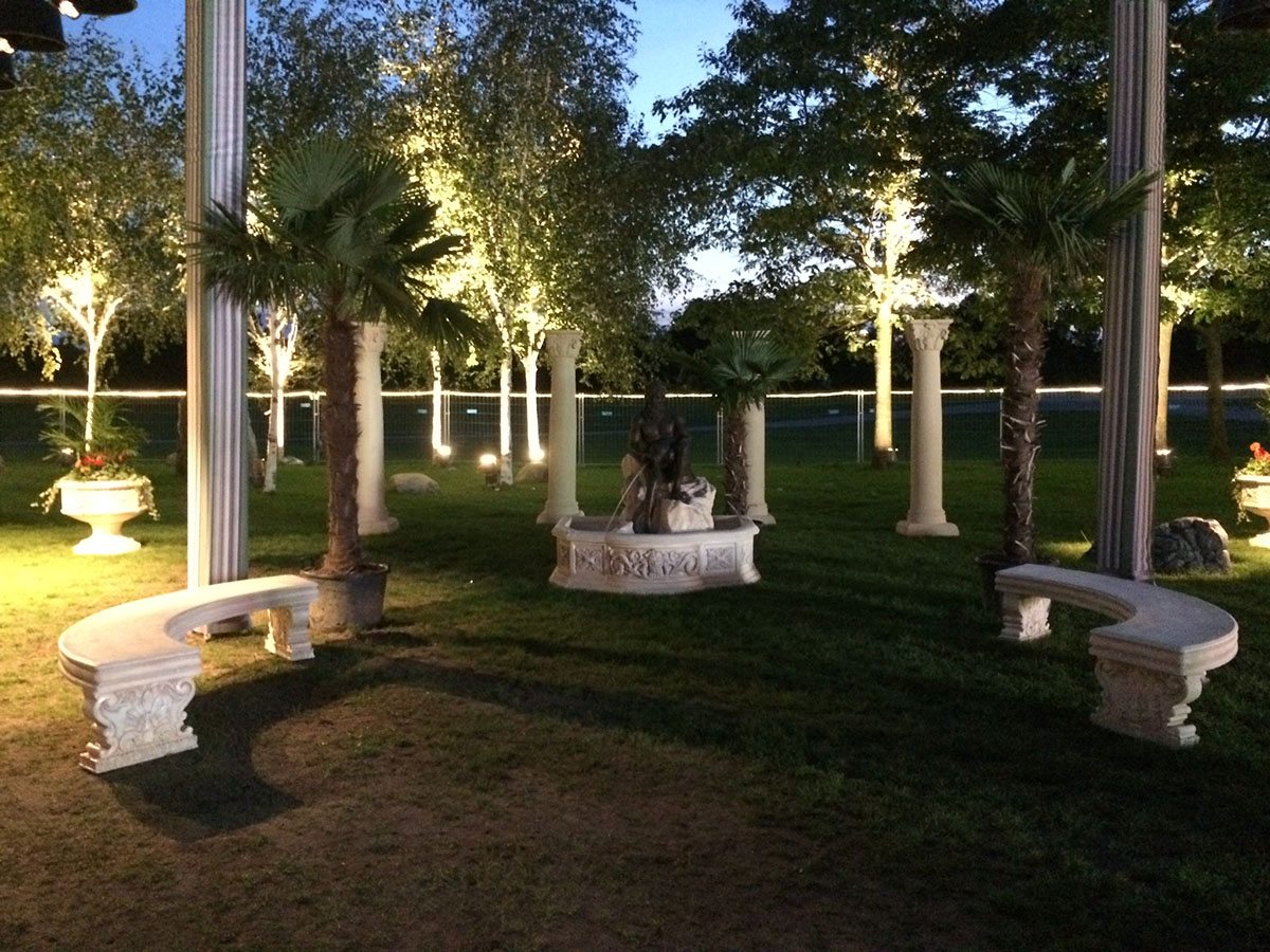 Haven er dekoreret med arkitektoniske søjler, palmer og hvide stenbænke 