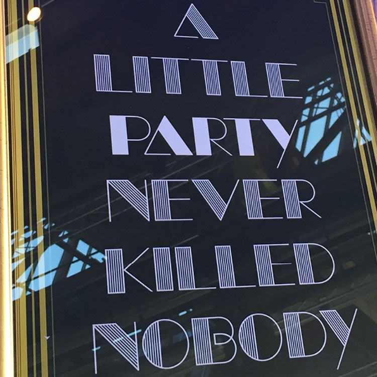 Et skilt står med teksten 'a little party never killed nobody' 