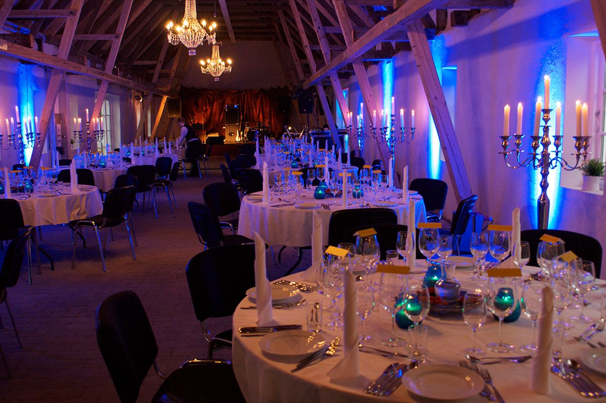 Til denne galla temafest er bordene dækket flot med hvide duge, sølvbestik, lys og dekorationer