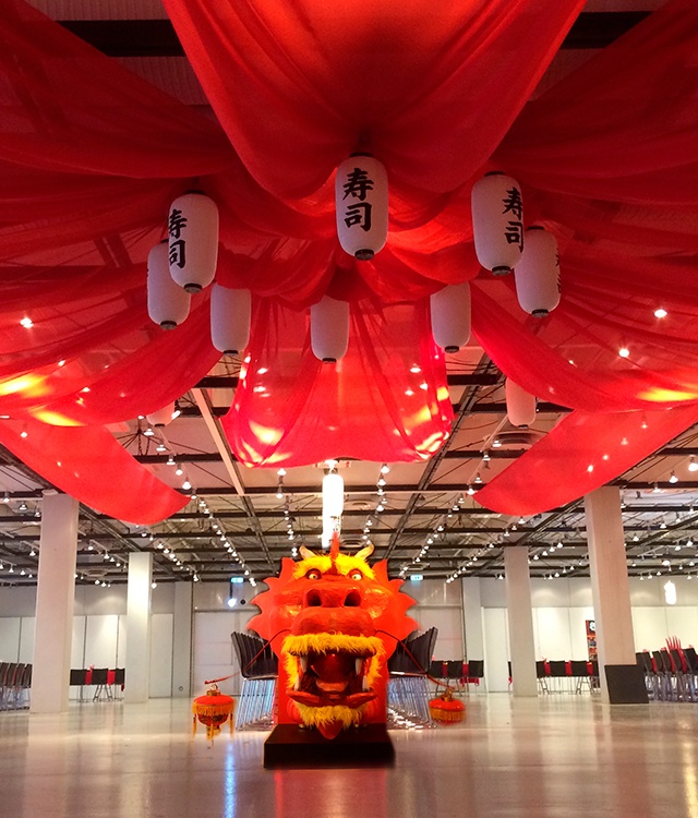 Til en asiatisk temafest er der pyntet med japanske ting som rødt stof og en stor drage 