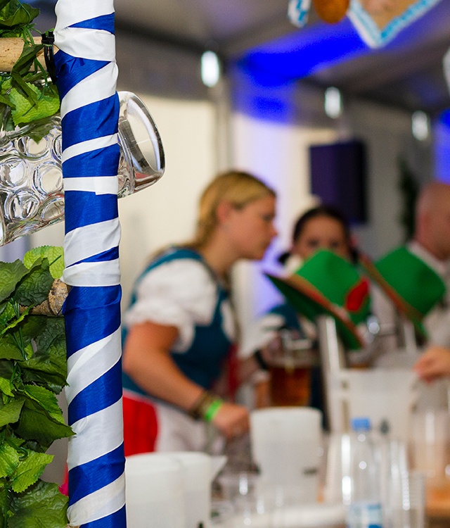 Oktober- og tyrolerfest er pyntet med ølkrus, blå og hvide bånd og bag baren står personale i tyrolertøj 