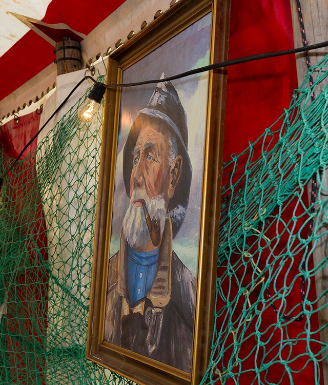 Sømands temafest er pyntet med fiskenet og et billede af en gammel fisker 