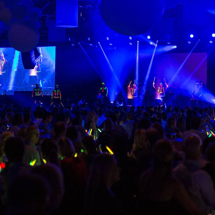 Dansere på scenen med neonlysdetaljer på tøjet til Velux 75 års jubilæum