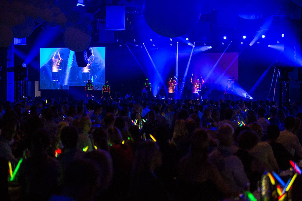 Dansere på scenen med neonlysdetaljer på tøjet til Velux 75 års jubilæum