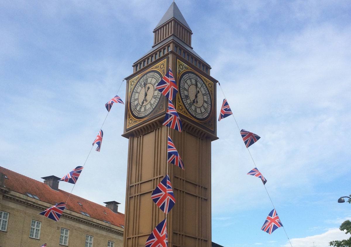 På Aarhus Banegårdsplads står Big Ben med britiske flag mod en blå himmel i forbindelse med Aarhus Cityforenings event ’Verdensbilleder/Midnatsåbent'