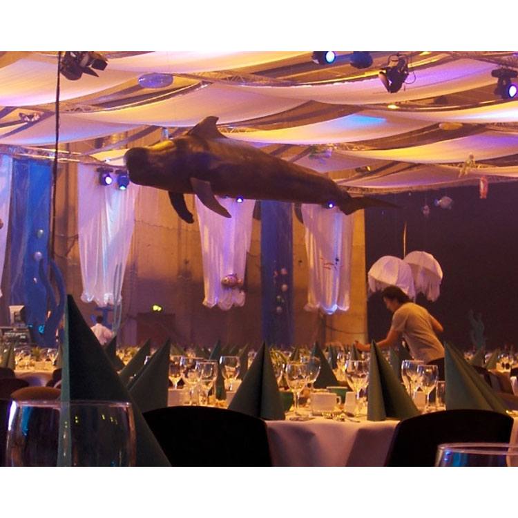 Over bordene hænger en specialfremstillet hval, hvide og blå løbere af stof hænger i loftet og på væggene 