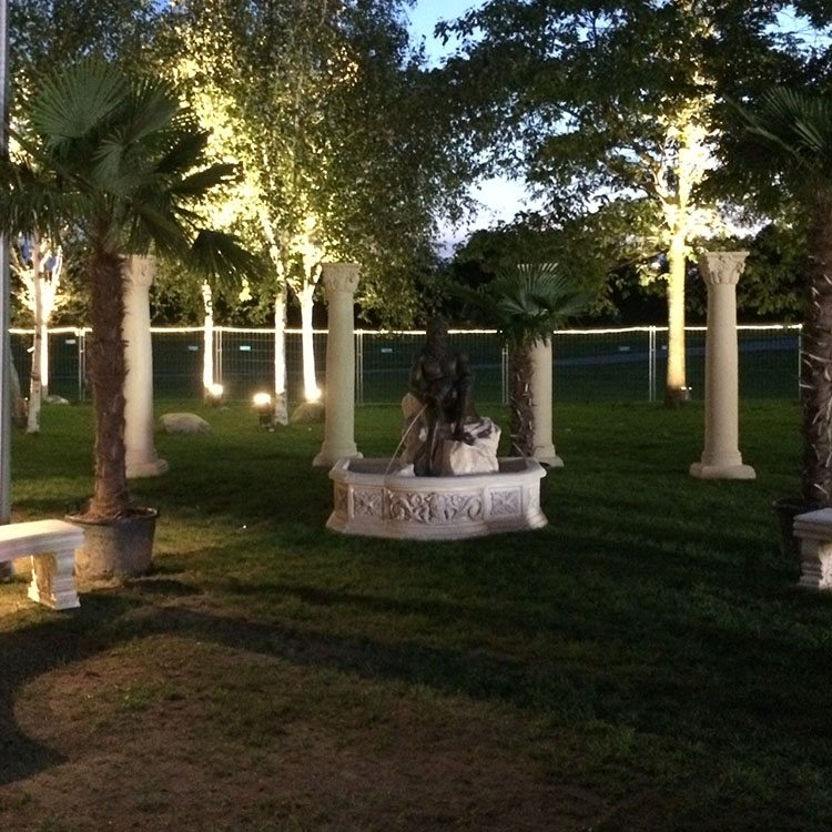 Haven er dekoreret med arkitektoniske søjler, palmer og hvide stenbænke 