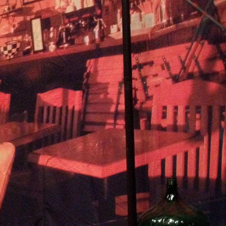 Billede af borde og stole i rødt lys 