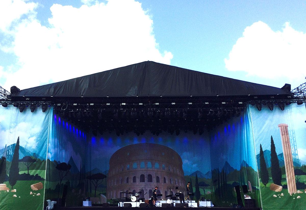 Scenen er dekoreret med et stort banner, hvor der er et billede af Colosseum 