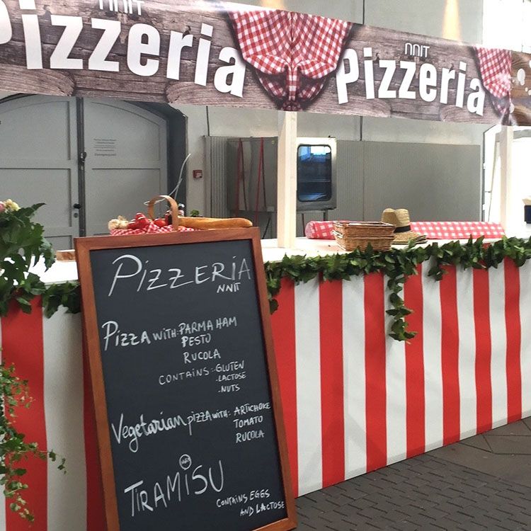 En italiensk pizzabod er dekoreret med rød og hvide farver, et menukort og et pizzeria skilt 