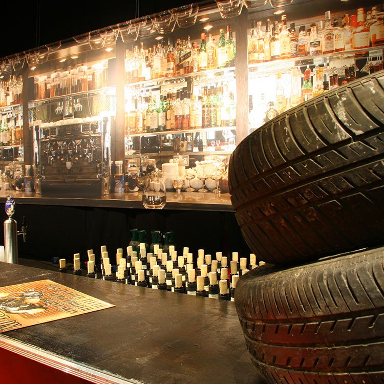 Bag baren hænger et banner, som forestiller en bar med masser af forskelligt spiritus 