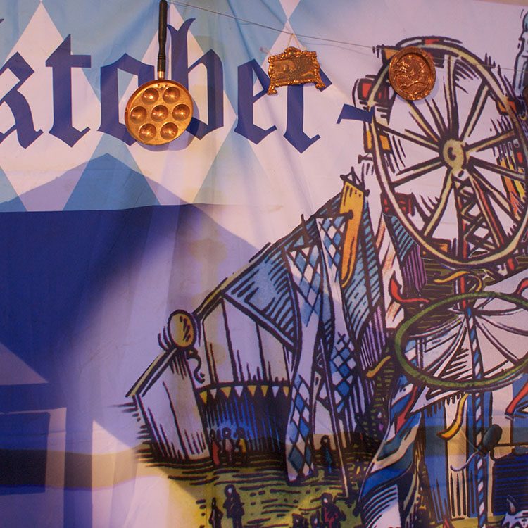 På væggen hænger et stort banner med billede af oktoberfest 