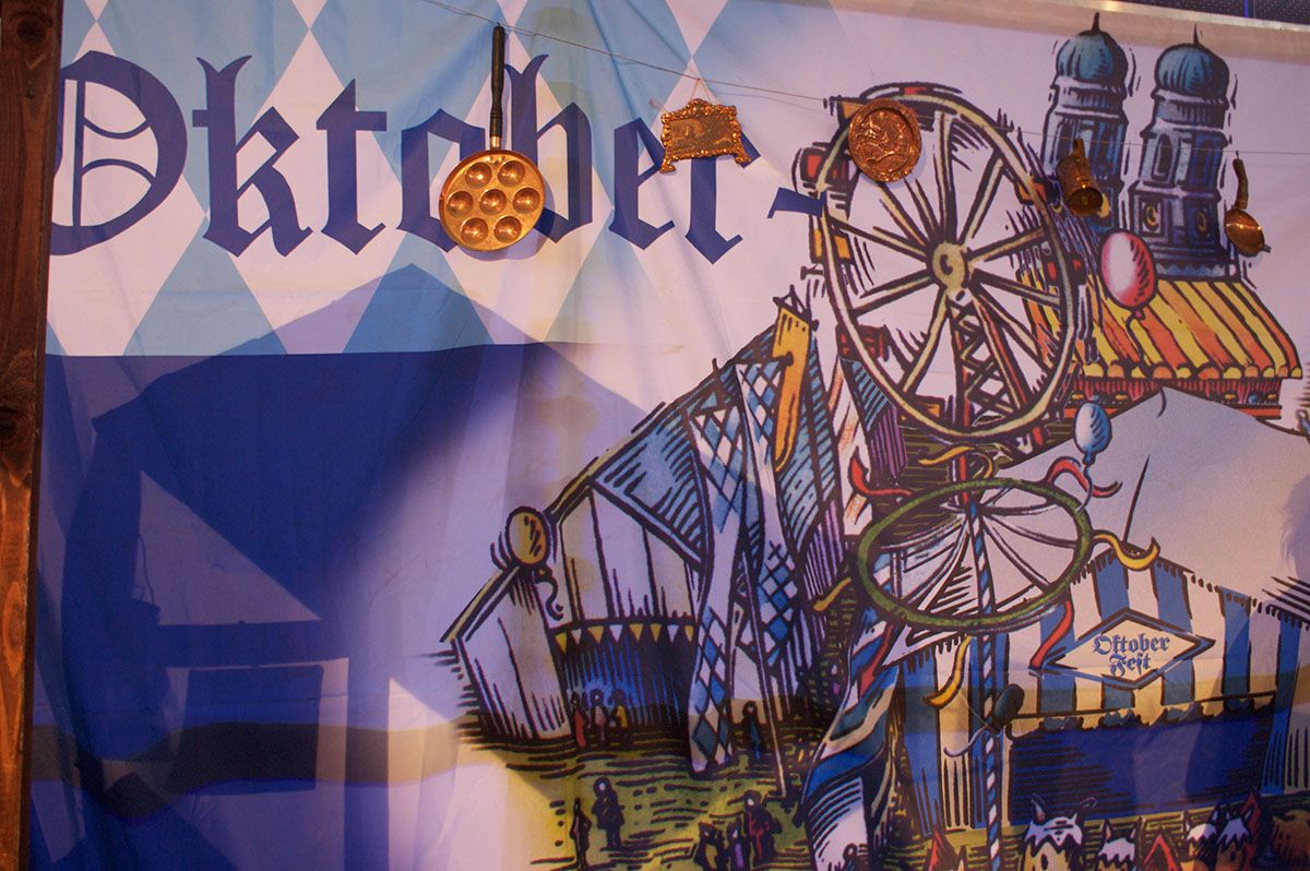 På væggen hænger et stort banner med billede af oktoberfest 