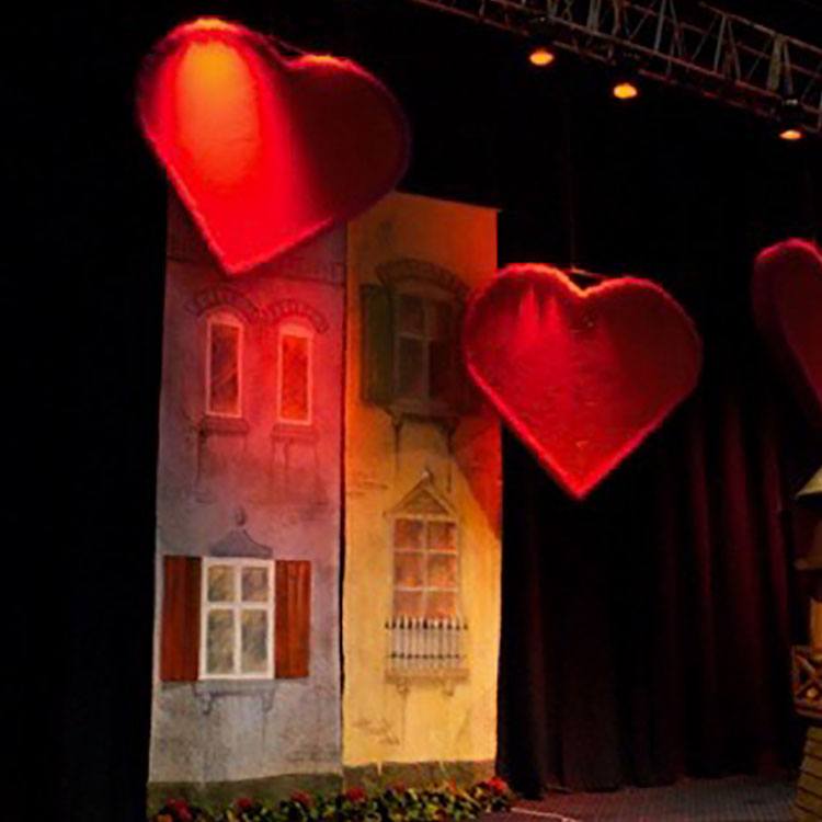 Facader af huse står langs væggen og røde hjerter hænger ned fra loftet 