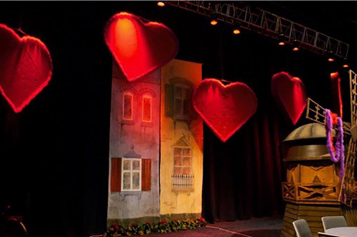 Facader af huse står langs væggen og røde hjerter hænger ned fra loftet 