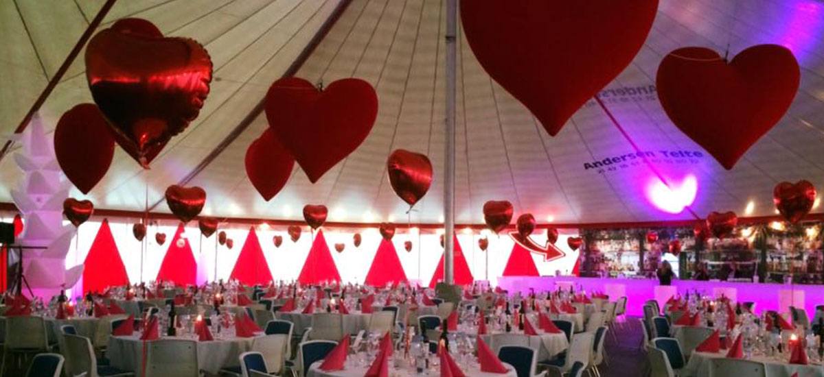 Denne Moulin Rouge fest er i et telt, hvor der hænger hjerter fra loftet 