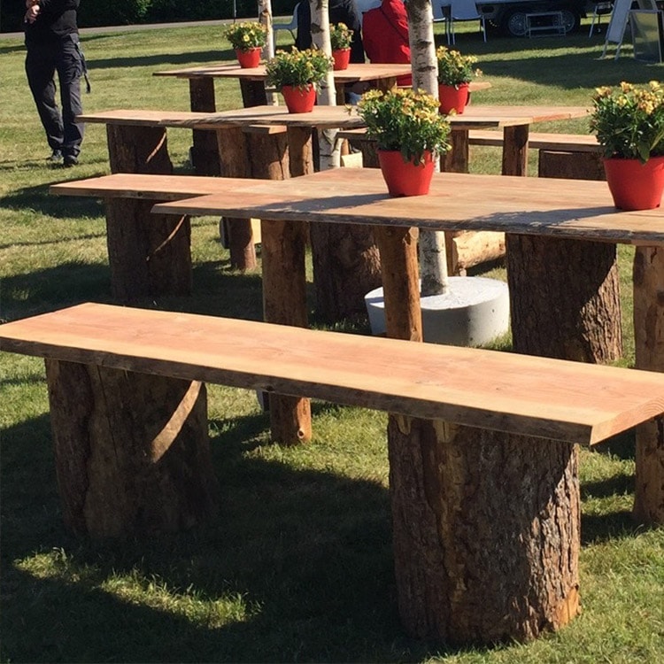 Udenfor er borde og bænke bygget i råt træ 