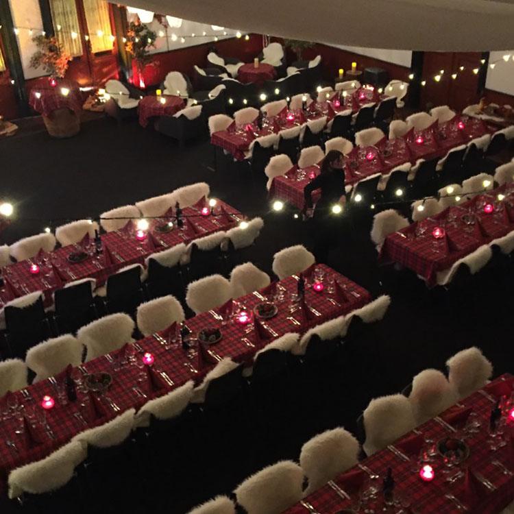 Her er skovmands temafesten set oppefra med røde duge på bordene og skind på stolene  