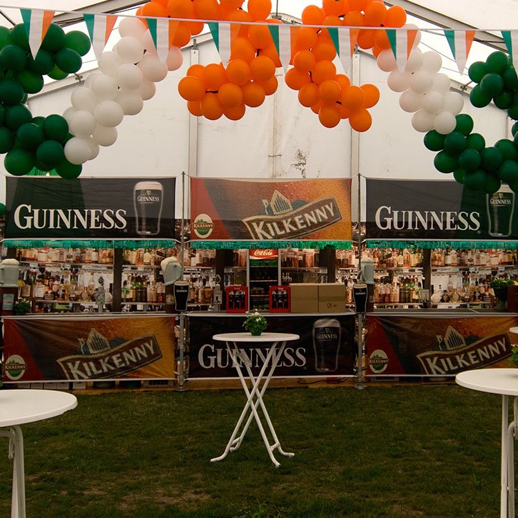 Et stort telt er pyntet med massevis af balloner, flag og andre irske elementer til Irish pub temafest 