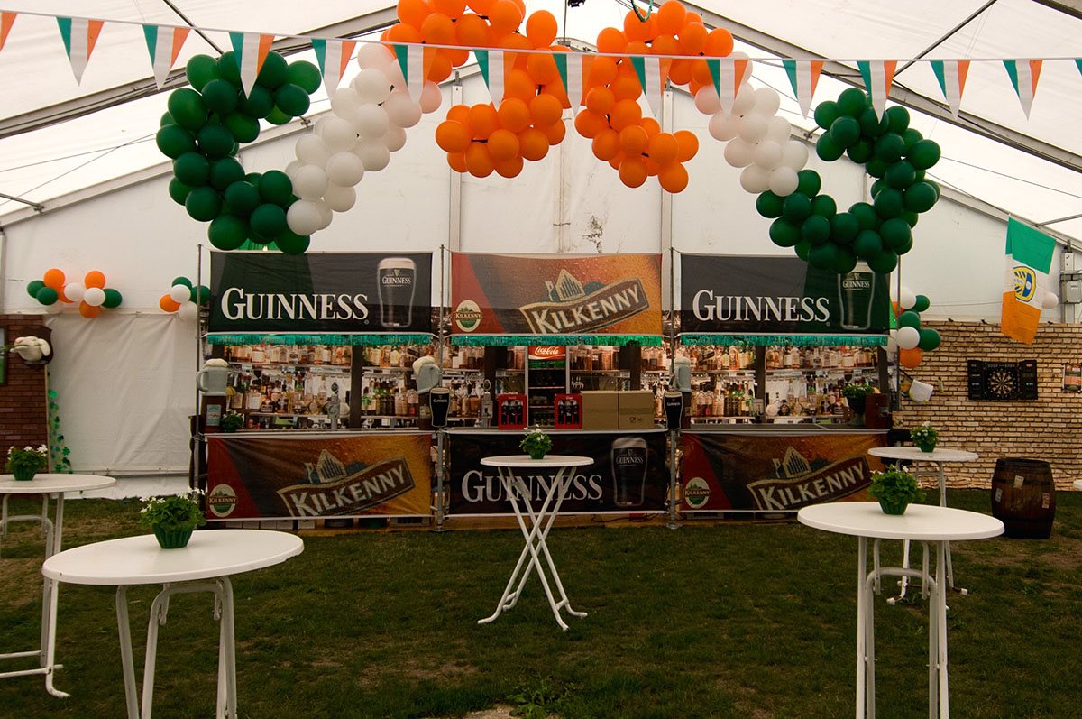 Et stort telt er pyntet med massevis af balloner, flag og andre irske elementer til Irish pub temafest 