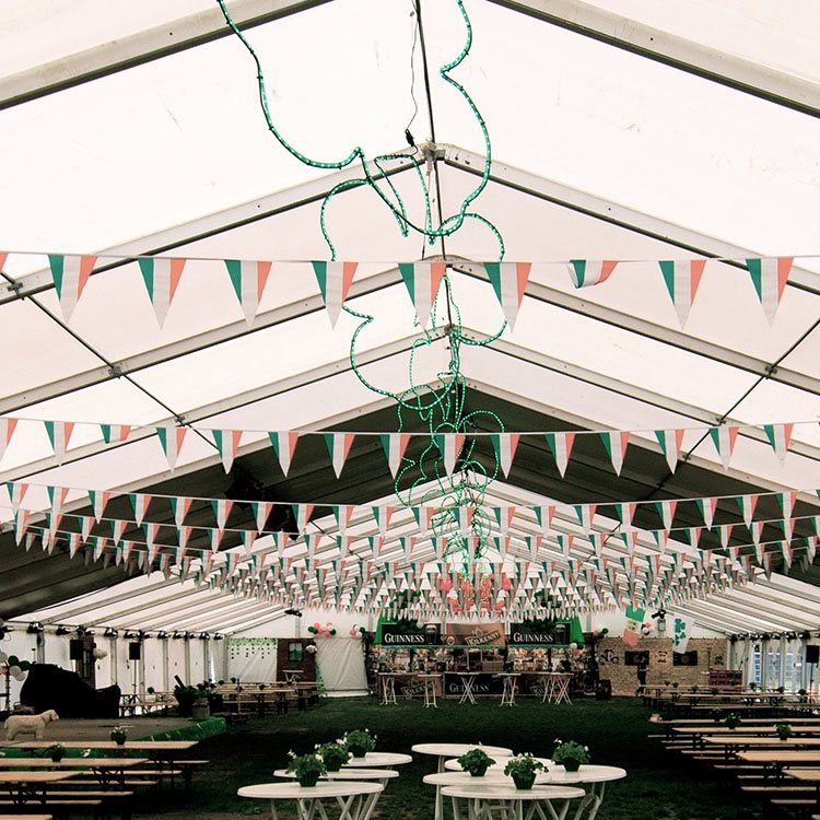 I det store telt står masser af borde og bænke. Langs loftet hænger irske flag