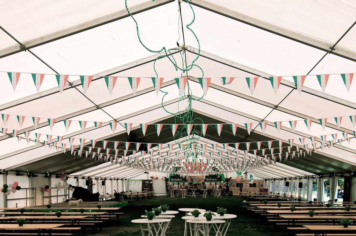I det store telt står masser af borde og bænke. Langs loftet hænger irske flag