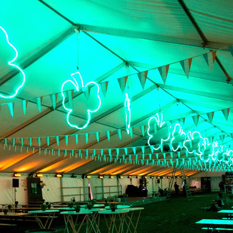 I et telt hænger store lysende trekløvere ned fra loftet sammen med irske flag. I siderne kastes orange lys op på teltdugen 