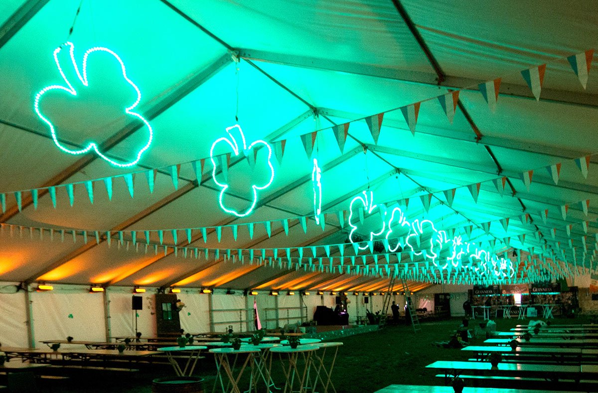 I et telt hænger store lysende trekløvere ned fra loftet sammen med irske flag. I siderne kastes orange lys op på teltdugen 