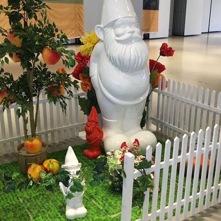 Her er pyntet med indhegnet græs, hvor der står et frugttræ, blomster og havenisser