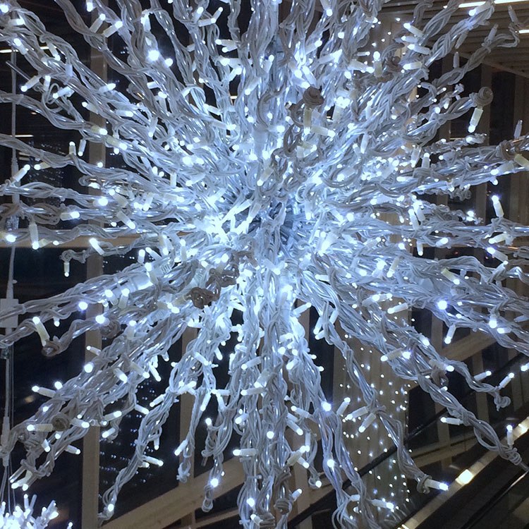 I loftet i dette shoppingcenter hænger der julekugler, stjerner og lys