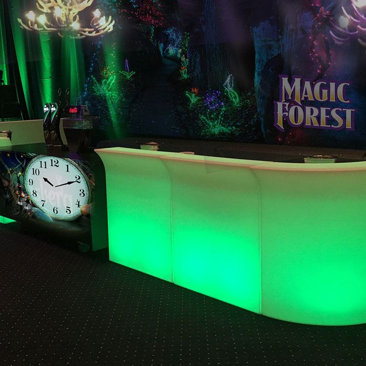 Baren er pyntet med grønt lys, et stort ur som uret fra Askepot og et stort banner med teksten 'magic forest' 