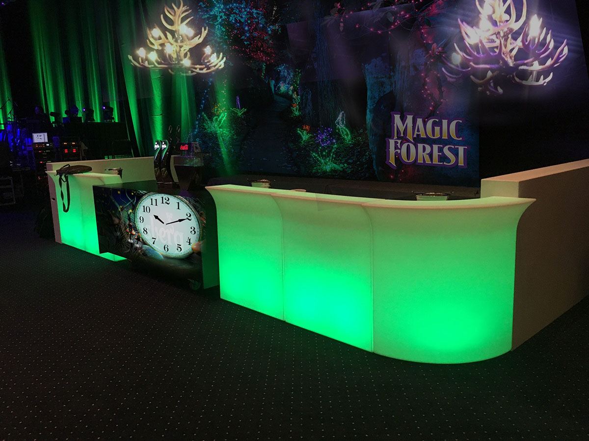 Baren er pyntet med grønt lys, et stort ur som uret fra Askepot og et stort banner med teksten 'magic forest' 