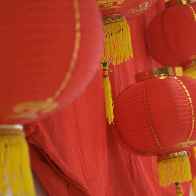 Røde, kinesiske lamper hænger langs væggen 